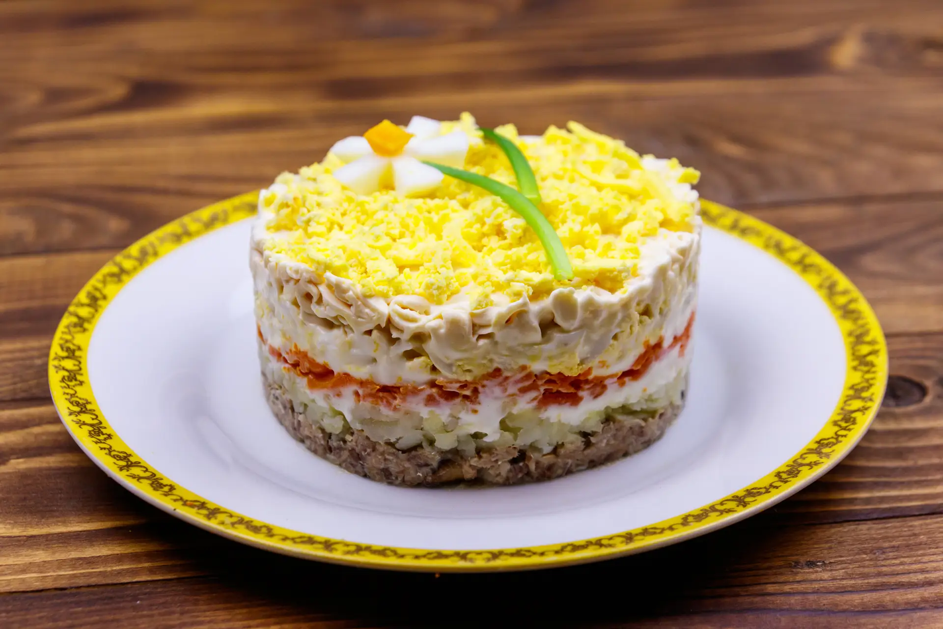 Slojevita salata sa žutim prelivom na tanjiru